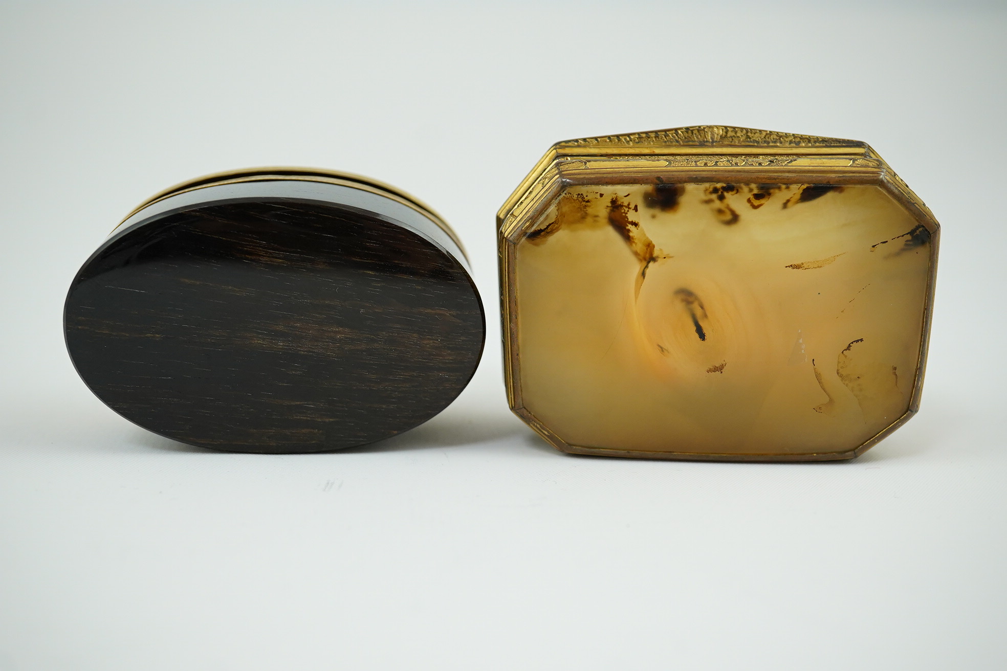 An early 19th century German gold mounted rutile agate? oval snuff box, 64mm and another gilt copper mounted agate snuff box.